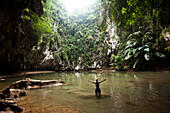 A beautiful young woman adventuring deep into a remote jungle pool relaxes in Thailand., Railay, Thailand