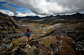 One man backpacking / hiking over a backcountry pass with fall colors., Anchorage, Alaska, USA