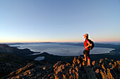 A female hiker enjoys a spectacular view of Lake Tahoe at sunset from the summit of Mount Tallac, CA., Lake Tahoe, California, USA