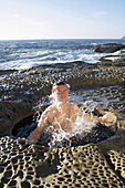 Man bathes in coastal waterhole Sydney, New South Wales, Australia