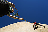 Woman belaying another climber, Bishop, California, United States