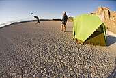 Woman and dog camp on dry lake bed Utah, United States