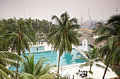 Swimming pool of a hotel, port of departure in background, Cotonou, Benin