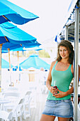 Young woman with drink at beach, Cape Cod, MA