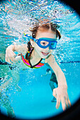 Asian girl swimming under water, Kauai, HI