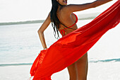 South American woman holding sarong at beach, Morrocoy, Venezuela