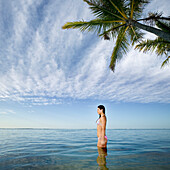 Pacific Islander woman standing in ocean, Hawaii