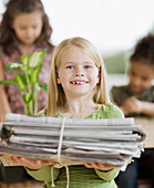 Girl holding bundle of newspapers, Jersey City, NJ