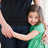 Mixed race girl hugging mother, Jersey City, New Jersey, United States