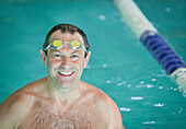 Smiling man with goggles in swimming pool, Stowe, Vermont, USA