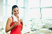 Mixed race woman drinking water in living room, Los Angeles, California, USA
