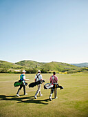 Men carrying golf bags on golf course, Mission Viejo, California, USA