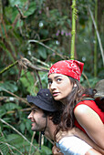 Hispanic man giving girlfriend piggyback ride in forest, El Retiro, Antioquia, Colombia