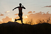 Kaukasische Frau läuft in abgelegenem Gebiet bei Sonnenuntergang, South Jordan, Utah, USA