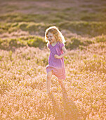 Caucasian girl running through field of flowers, Lehi, Utah, USA