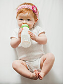 Caucasian baby girl drinking bottle, Lehi, Utah, USA