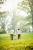 Parents walking with daughter in field, Saint Louis, MO, USA
