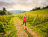 Kaukasische Frau, die in einem Weinberg läuft, Neuchatel, Neuchatel, Schweiz
