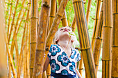 Caucasian girl looking at bamboo stalks, Kauai, Hawaii, USA