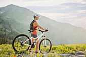 Caucasian woman with mountain bike looking at view, Alta, Utah, USA