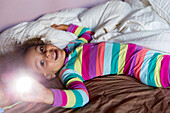 Mixed race girl smiling on bed, Portland, OR, USA