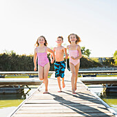 Caucasian children running on dock, American Fork, Utah, USA