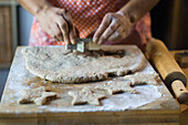 Mixed race woman cutting cookie dough in kitchen, Austin, TX, USA