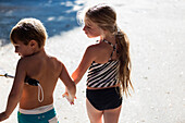 Children in swimsuits holding hands outdoors, Brunswick, Georgia, United States