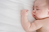 Hispanic baby boy sleeping on bed, New York, New York, USA