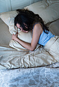 Hispanic woman sleeping in bed, Jersey City, NJ, USA