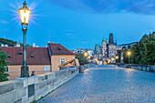 Illuminated streetlamps on cobblestone bridge at dawn, Prague, Czech Republic, Budapest, Central Hungary, Hungary