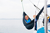 Woman relaxing in a hammock on board of a sailing boat, Pula, Istria, Croatia