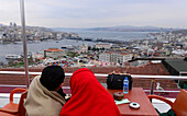 Paar sitzt in einem Café mit Blick über Sultanahmet auf Galatabrücke, Istanbul, Türkei