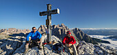 Two mountaineers at the summit cross of Oberbachernspitze, Neunerkofel, South Tyrol, Dolomites, Italy