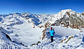 Femal back-country skier ascending to Agglsspitze, mountain scenery in background, Pflersch valley, Stubai Alps, South Tyrol, Italy