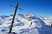 Wooden cross in snow with mountain scenery in background, Agglsspitze, Pflersch valley, Stubai Alps, South Tyrol, Italy