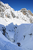 Back-country skiers ascending through a canyon to Cristallo wind gap, Cristallo, Dolomites, Belluno, Veneto, Italy