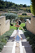 Frau tanzt auf den Treppenstufen im Hotelgarten, Hotel Les Andeols, Saint-Saturnin-les-Apt, Provence, Frankreich