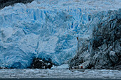 Sailing boat passing a glaciar, Fjordo Pia, Cordillera Darwin, Tierra del Fuego, Chile