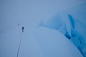 Two mountaineers in a whiteout on a glacier below Monte Sarmiento, Cordillera Darwin, Tierra del Fuego, Chile