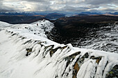 Bergwanderer beim Abstieg im Schnee vom Beinn Dearg, Highlands, Schottland, Großbritannien