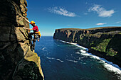Climber ascending Old Man of Hoy, Hoy, Orkney Islands, Scotland, Great Britain