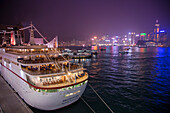 Cruise ship MS Deutschland, Reederei Peter Deilmann, at Ocean Terminal with skyline across Hong Kong Harbour at night, Tsim Sha Tsui, Kowloon, Hong Kong