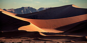 rote Sand Dünen und Berge am Horizont bei Sossusvlei, Namib Naukluft Park, Namibia, Namib Wüste, Afrika