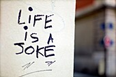 graffiti written on a wall, life is a joke