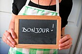 Housewife with a blackboard with ´Bonjour´ in handwritten