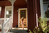 Young girl running towards front door