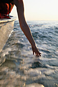 Senior woman in motorboat, hand in water