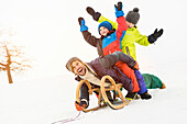 Man with two boys on toboggan in snow