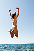 Woman jumping into sea